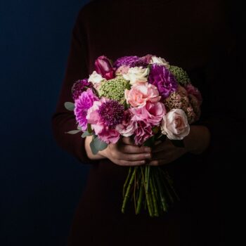 posy of pink flowers including lisianthus dahlia scabiosa sedum on a base of poly gum eucalyptus foliage